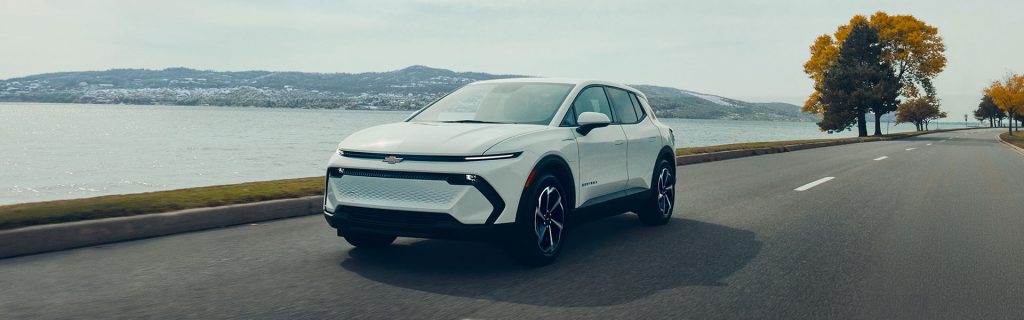 2026 Chevrolet Equinox EV driving along a scenic coastal road